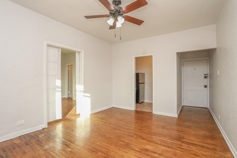 a bedroom with hardwood floors and a ceiling fan